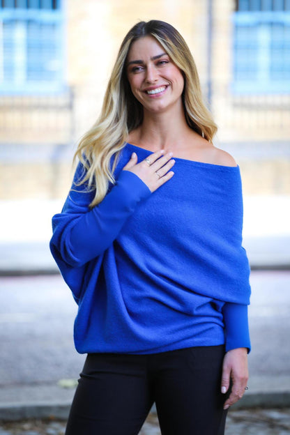 Woman wearing a blue off-shoulder jumper